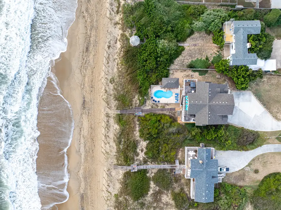 Straight-down aerial of oceanfront home with waves breaking